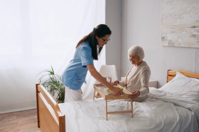 a nurse helping an old person in a hospital bed